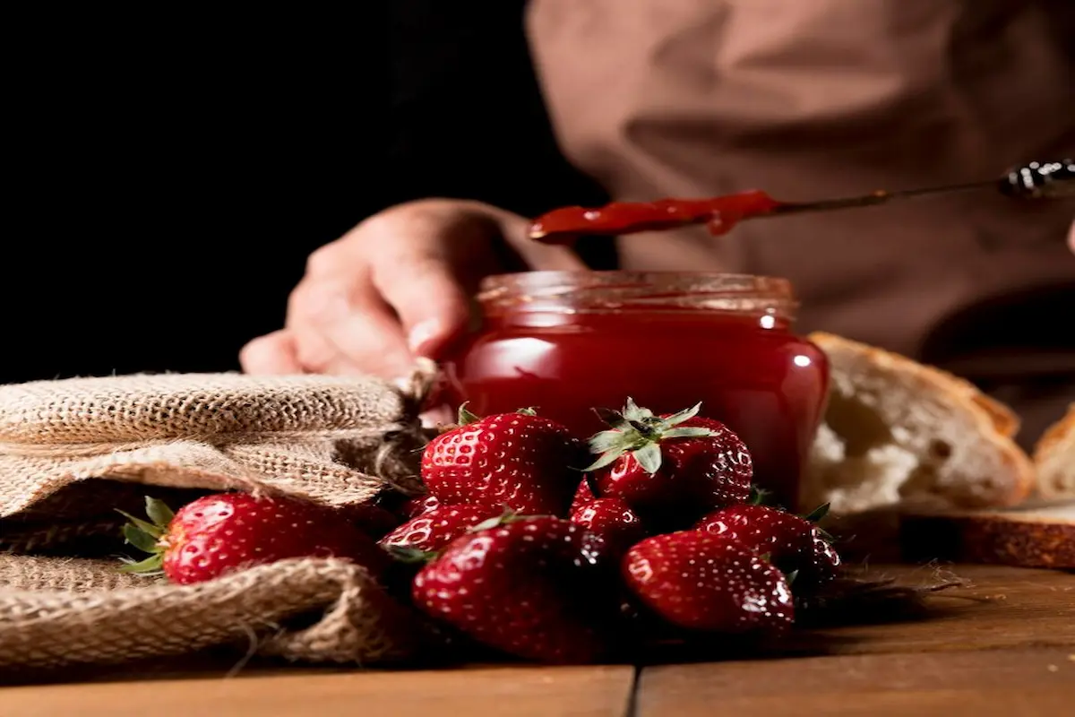 Sealing freshly made strawberry jam in glass jars