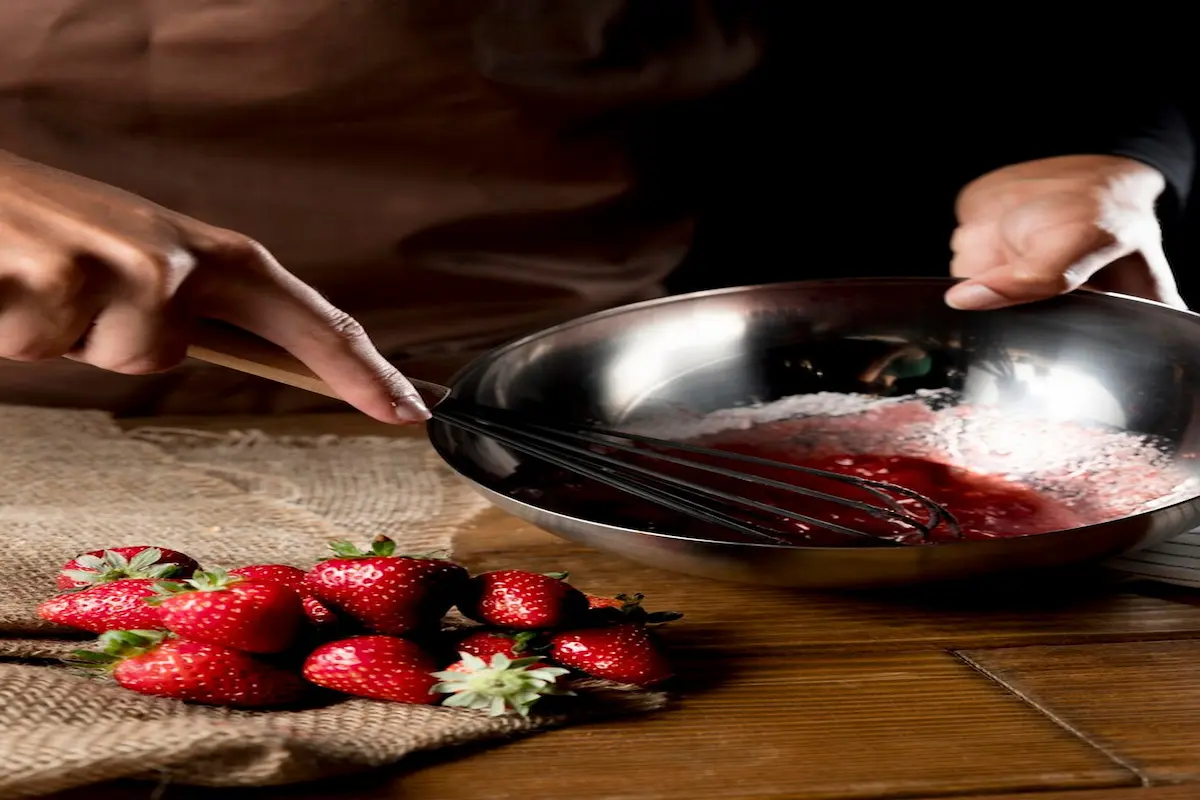 Preparing strawberries for jam making by washing and hulling