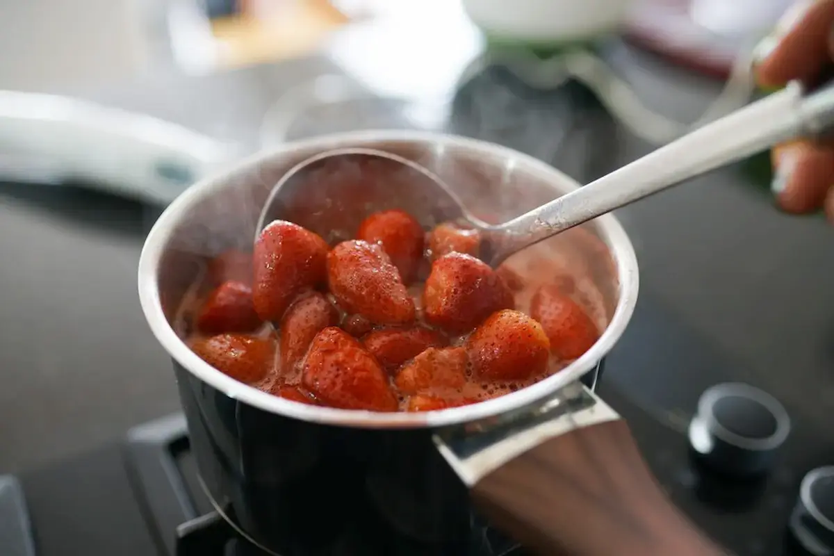 Simmering strawberries and pectin mixture on the stove for jam